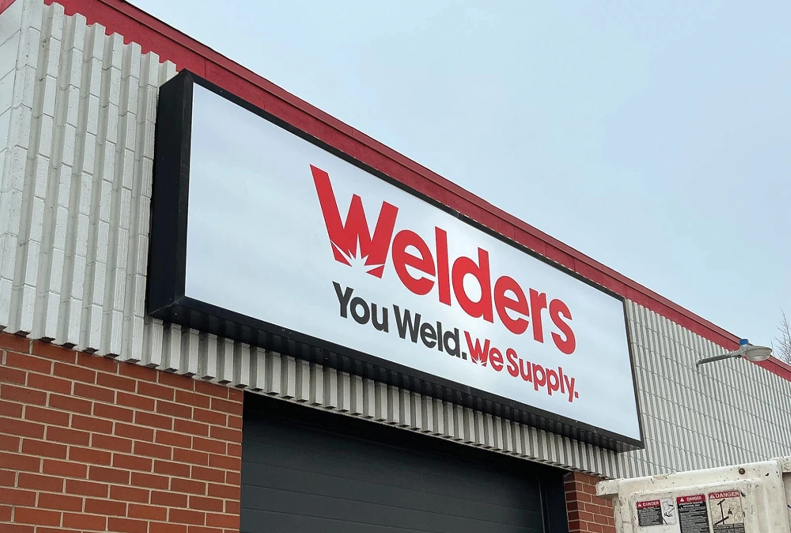 Illuminated white cabinet sign with red lettering