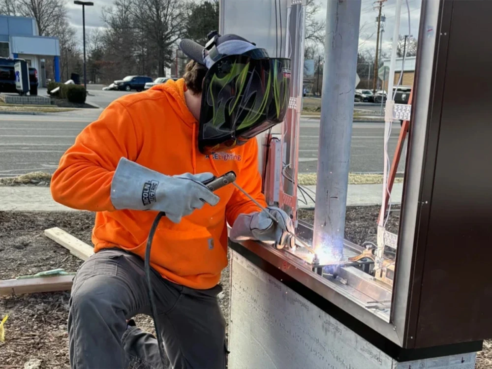 Technician welding on a pylon sign