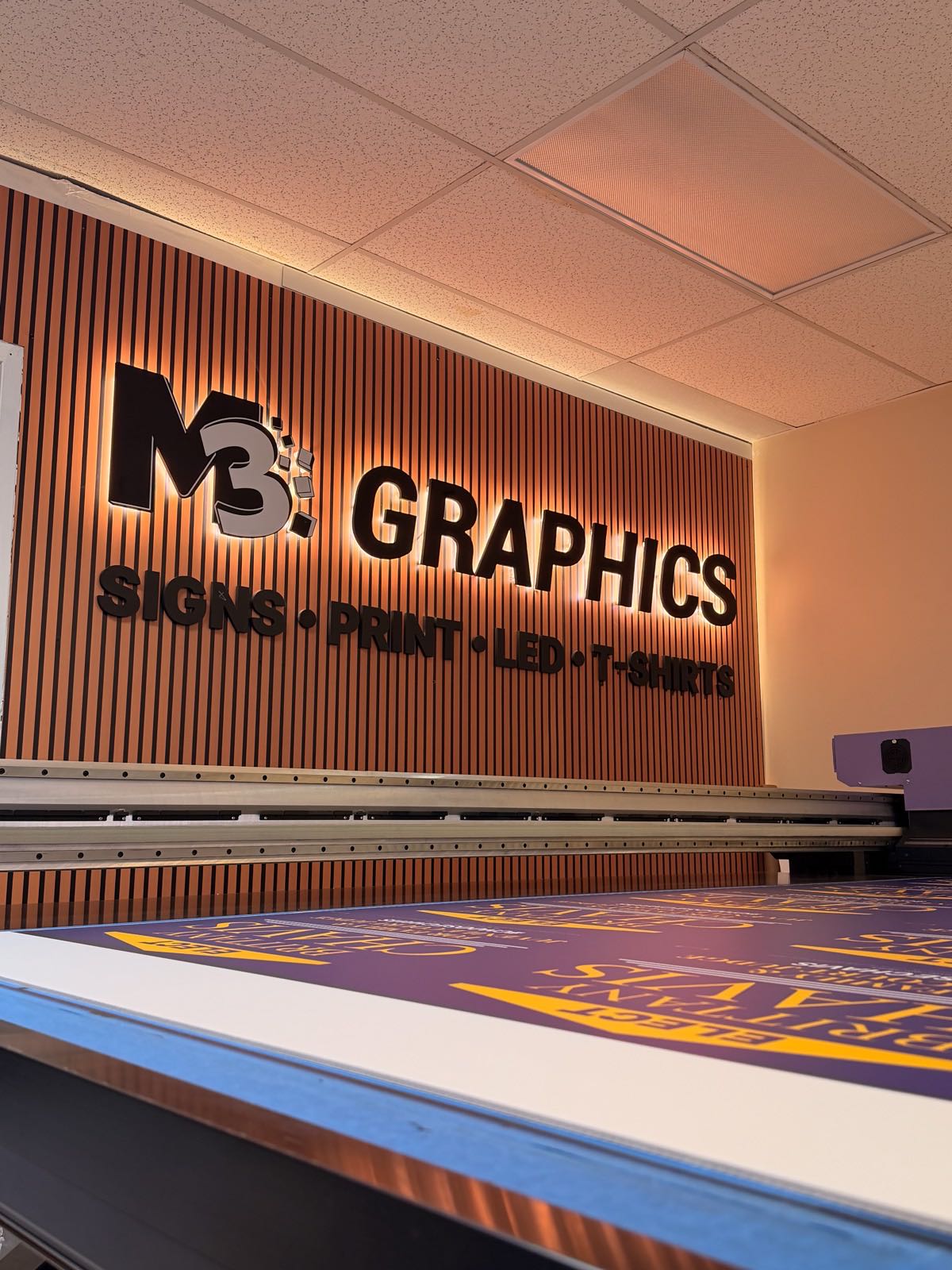Illuminated interior wall sign inside the M3 Graphics shop
