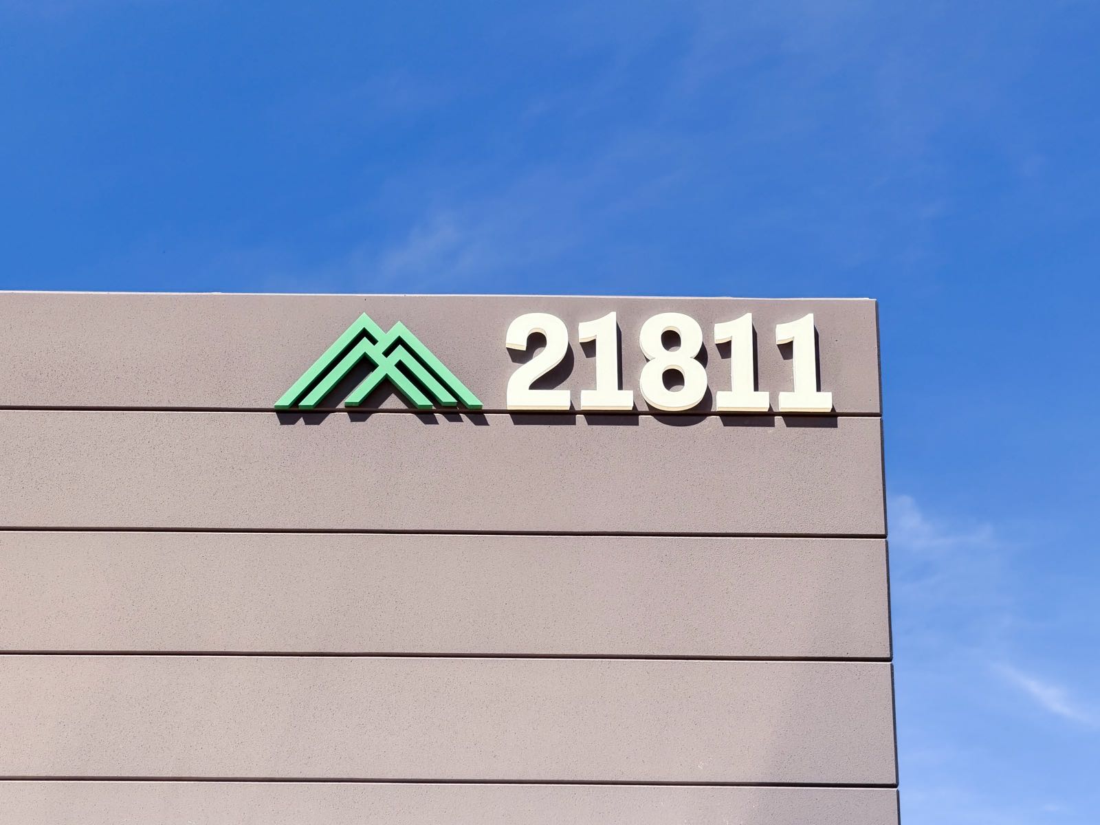 Summit Grove building sign with a green mountain logo and 3D address numbers